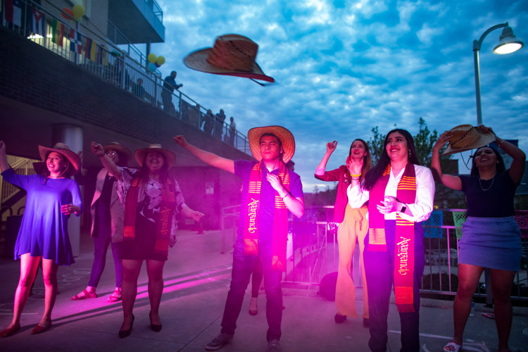 A hat flies in the air as Jonny Gutierrez celebrates at an outdoor Avanzando party
